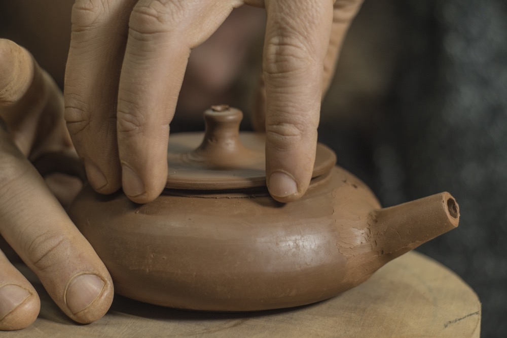 Artisan fabriquant une théière en argile de Yixing