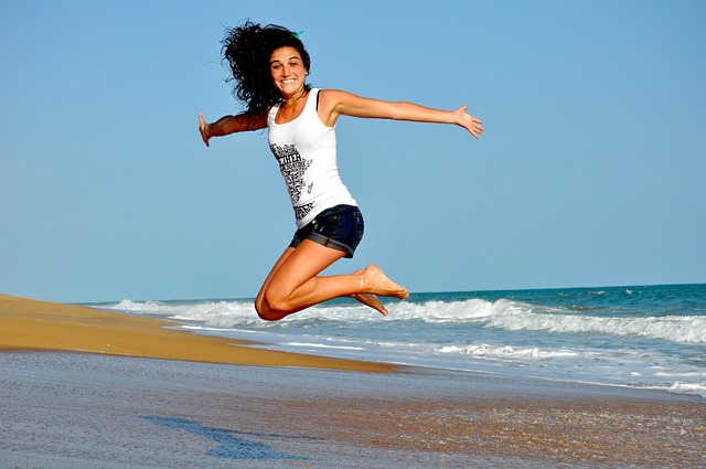 Jeune femme sautille sur une plage