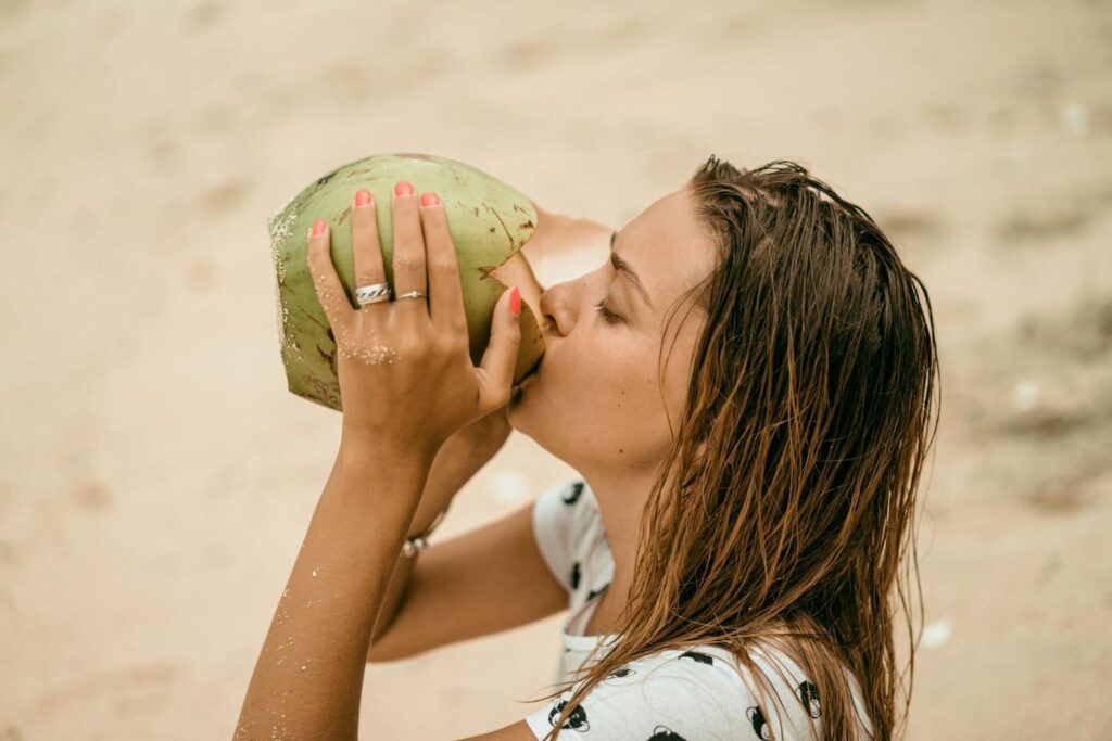 jeune femme boit de l'eau de coco