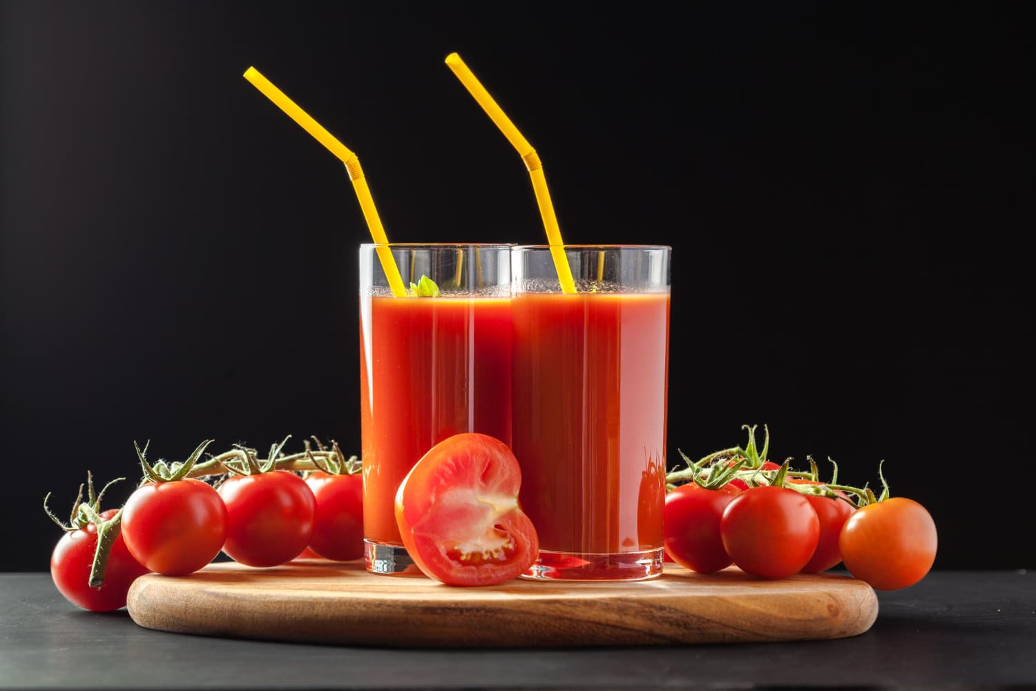 jus de tomate avec tomates cerises sur fond noir