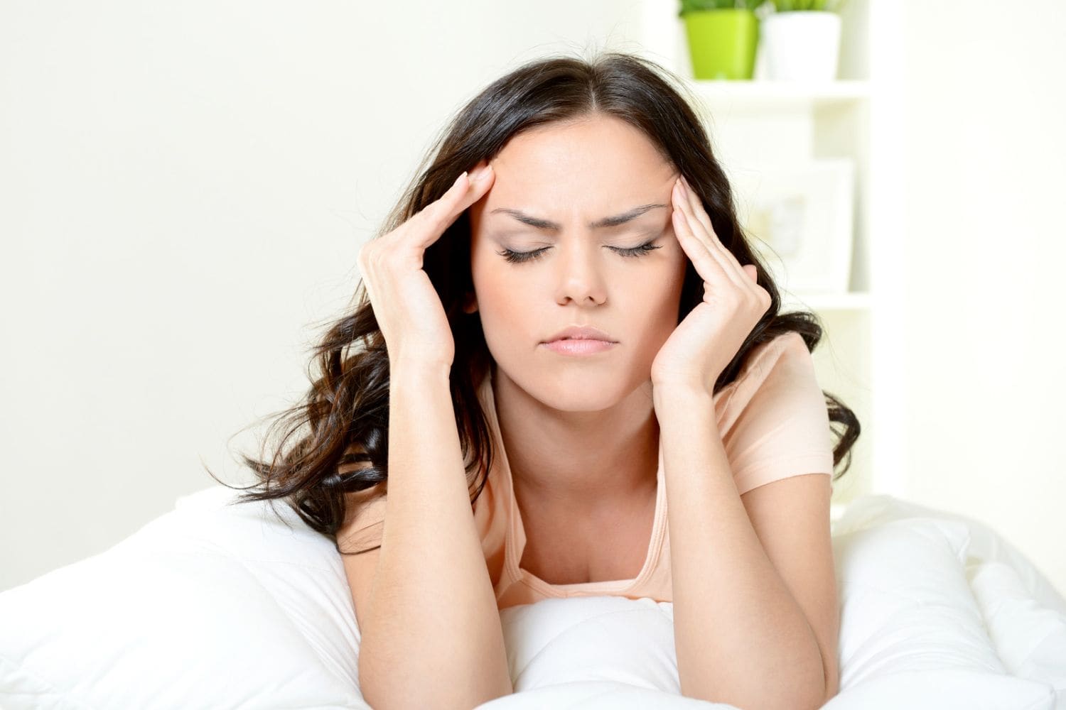 jeune femme souffre d'une migraine et se masse les tempes