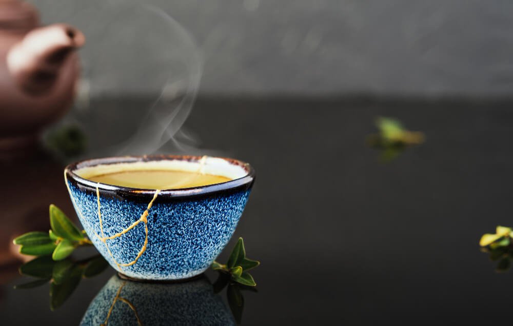 tasse de thé vert sur fond noir avec vapeur