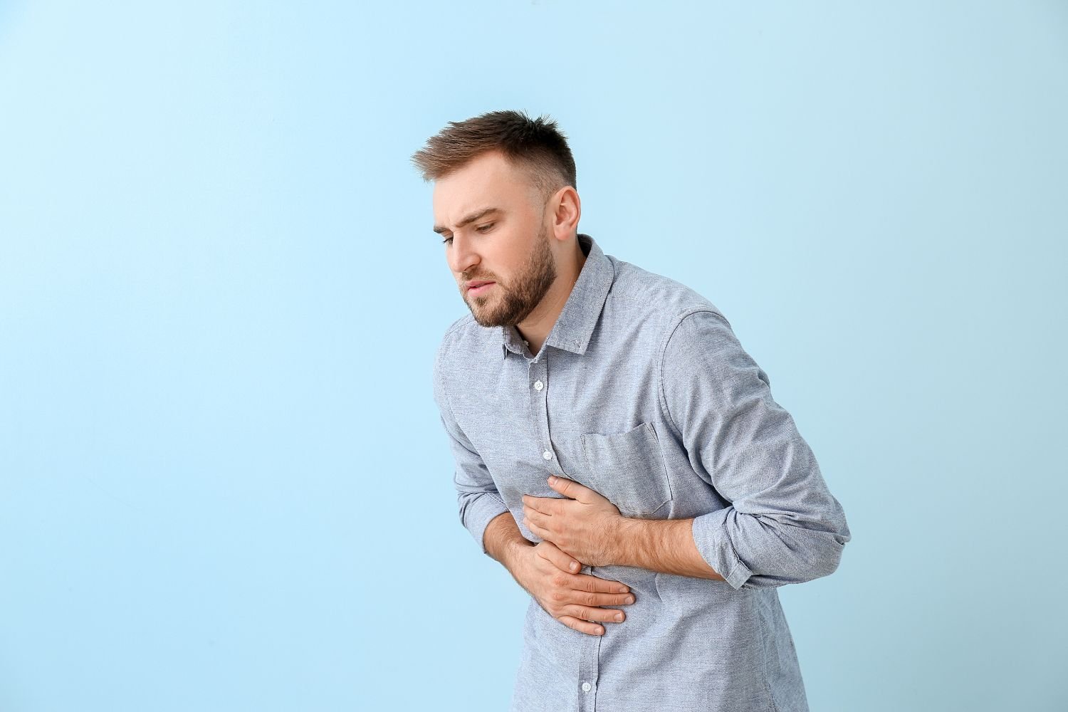 homme avec une gastro se tient le ventre